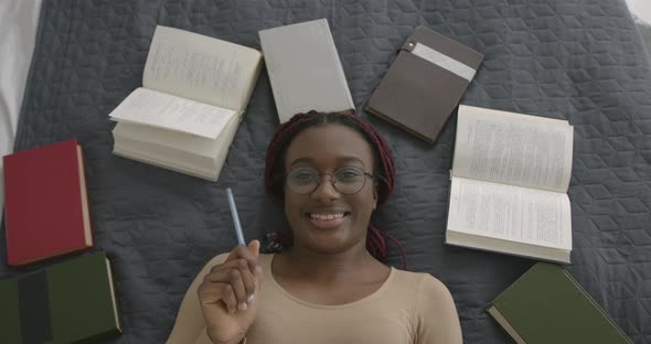 Black Race Girl Studying While Lying in Bed