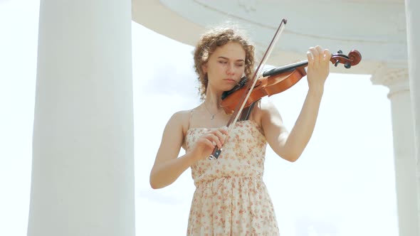 young curly blond woman the violinist: Musician playing violin