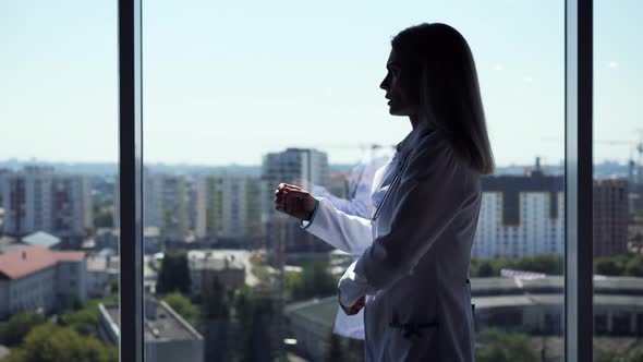 Silhouette of Doctor Walking in Hospital Near Panoromic Window Stress Day