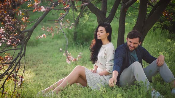 Young Lovely Couple in Spring Blooming Park Outdoors