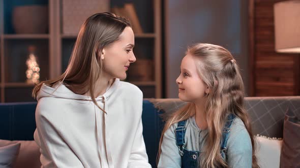 Happy Mother and Daughter Smiling Touching Noses Feeling Love and Tenderness at Cozy Evening Home