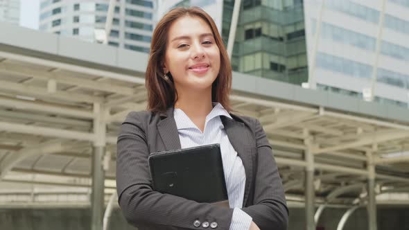 Asian young smart businesswoman working in company office, stand outdoor in city with smiling face