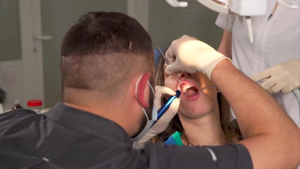 Dentist Providing Teeth Cleaning for a Woman Patient