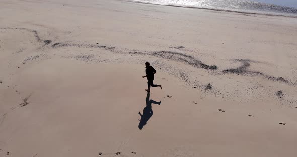 Drone Shot Following A Man Running On A Beach, On Langeoog Island