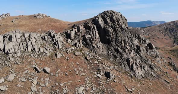 Macin Mountain Range With Craggy Cliff In Summer Near Tulcea County In Dobrogea, Romania. - aerial