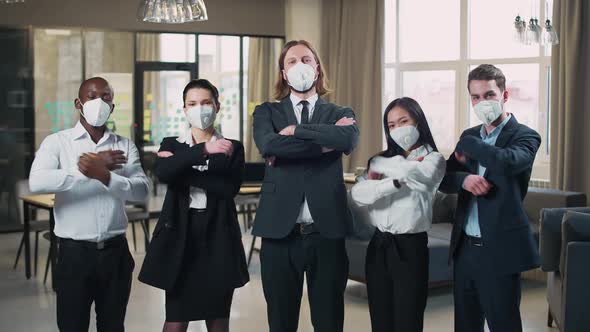 Office Team Stands and Looks at the Camera Managers in Protective Medical Masks Working 