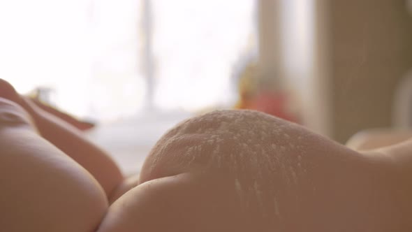 Mother applying baby powder to child skin