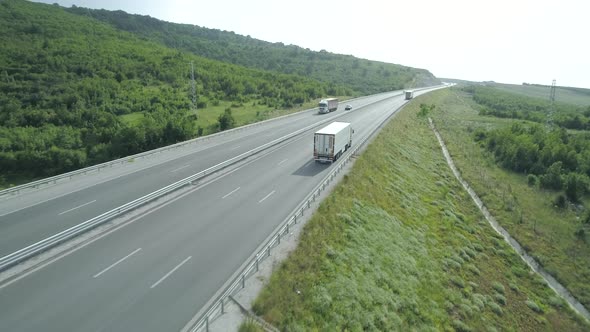 Slow Motion Drone Footage of Big Cargo Trucks Driving on Highway in the Summer