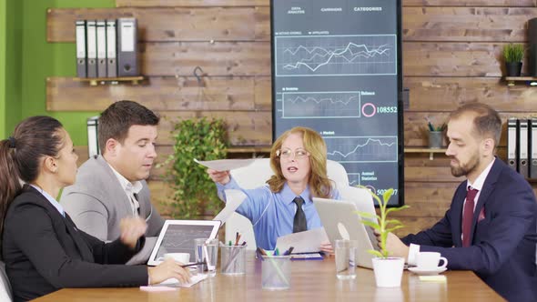 Female Manager Presents New Project Plan To Colleagues at Meeting