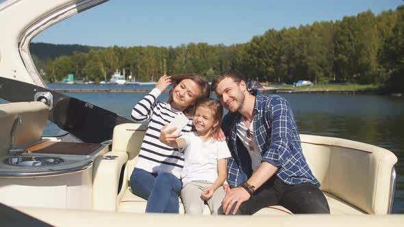 Family with Daughter Vacation Together on Sailboat in Lake