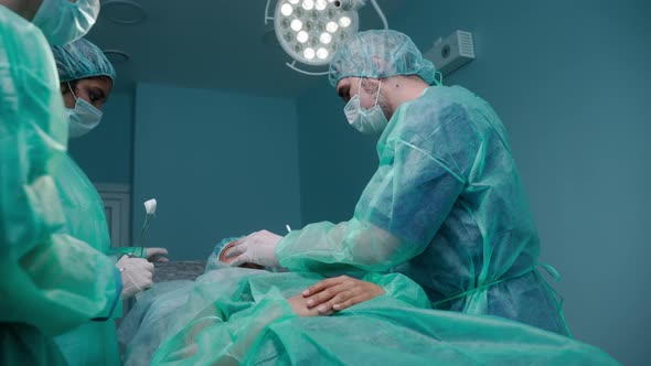 Three Surgeons Performing Rhinoplasty in Green Protective Gowns