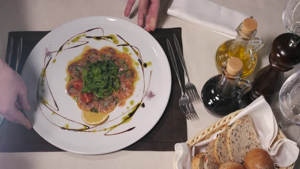 Beef o Fish Carpaccio with Parmesan Lemon and Arugula in Modern Restaurant Top View