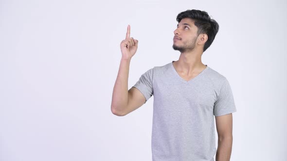 Young Happy Bearded Indian Man Thinking While Pointing Up