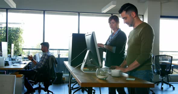 Executives discussing over desktop pc at desk 4k