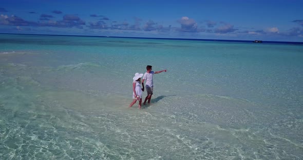 Beautiful boy and girl on honeymoon vacation enjoy life on beach on white sand 