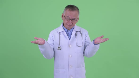 Sad Mature Japanese Man Doctor Shrugging Shoulders