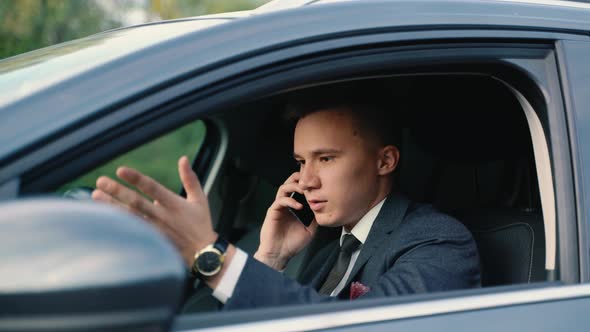 Stressed Businessman Calling on a Mobile Phone in the Car