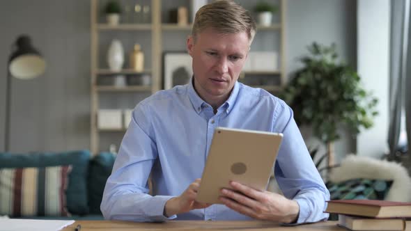 Businessman Cheering for Success While Using Tablet