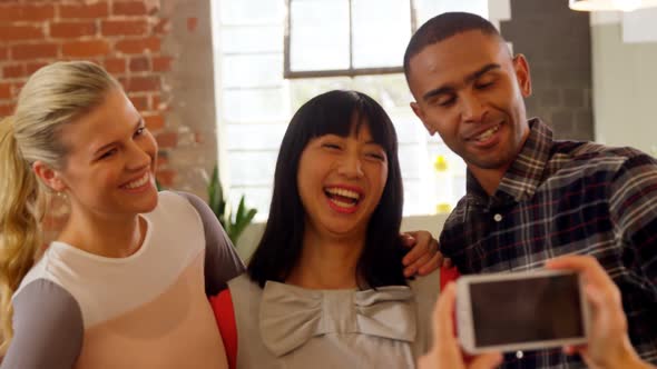 Group of executives reviewing picture on mobile phone 4k