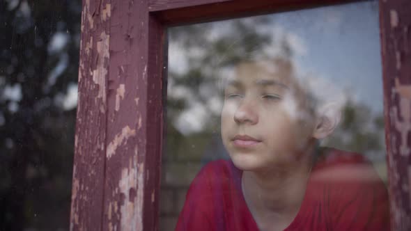 Boy at Home Look at the Window and Puts on a Mask Before Going Outside Covid 19