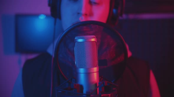 A Man Rapping Through the Pop-filter in the Microphone - Recording His Track in the Studio