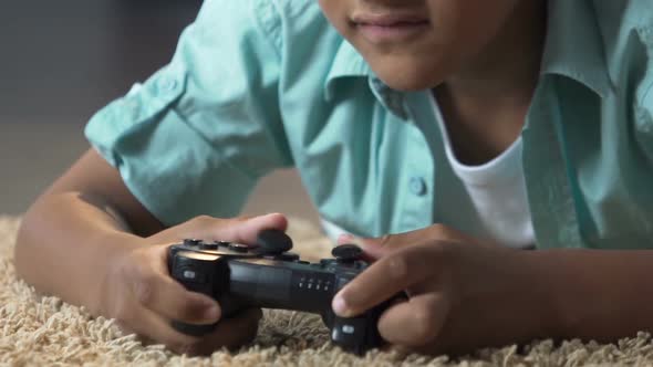 Little Child Lying on Floor with Play Station Control Playing Video Games, Anger