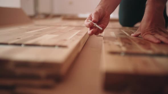 Man Putting Rivets To Assemble New Wooden Table - close up