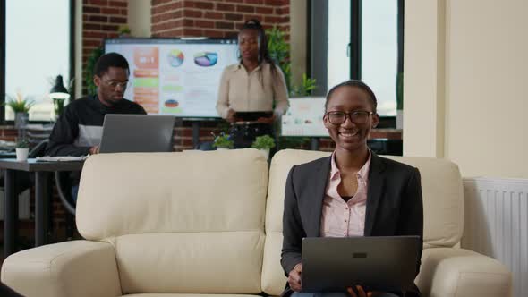 Portrait of African American Woman Holding Laptop on Sofa