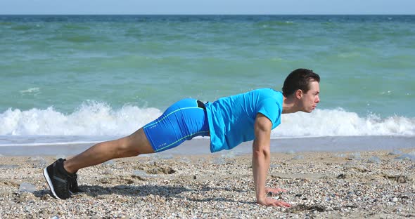 Young Man Doing Push-ups Exercise at Ocean Beach