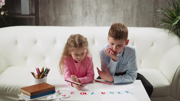 Couple of Children Learns Digits with Cards at Coffee Table