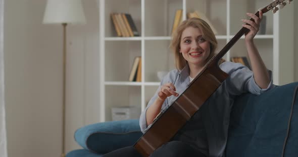 Funny Woman Is Playing Guitar Unusually and Laughing Experiment with Musical Instrument and Joke at