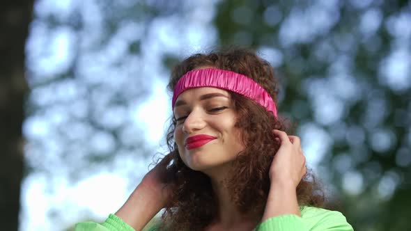 Closeup Confident Young Woman in Hair Band Looking Away Smiling Standing Outdoors in Summer Park