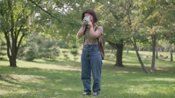 Wide Shot Talented Positive Little Woman Taking Photos of Nature on Camera Standing in Sunny Forest