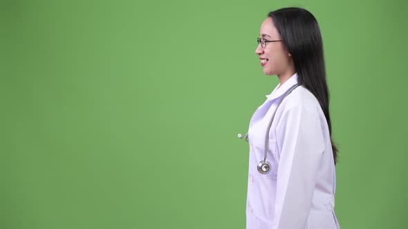 Profile View of Young Beautiful Asian Woman Doctor Smiling