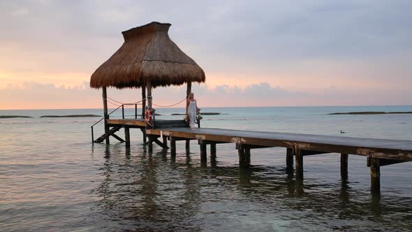 Woman walking on pier at tropical resort