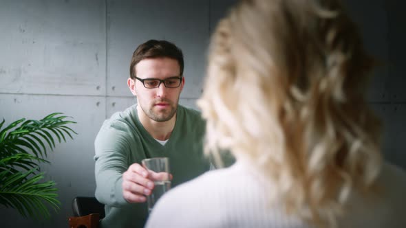 Professional with glasses talking to a patient on the couch