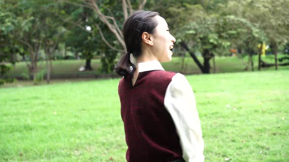 Young Attractive Asian Woman in School Uniform Turn Around and Smile in the Park Outdoor