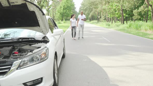 Couple Waiting for Tow Truck Service on Countryside Road