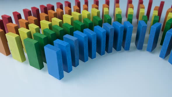 Line up of Dominoes in Rainbow Falling Colors with LGBT Colors of a Hand