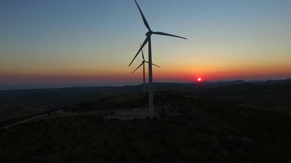 Flying over windmills at dusk