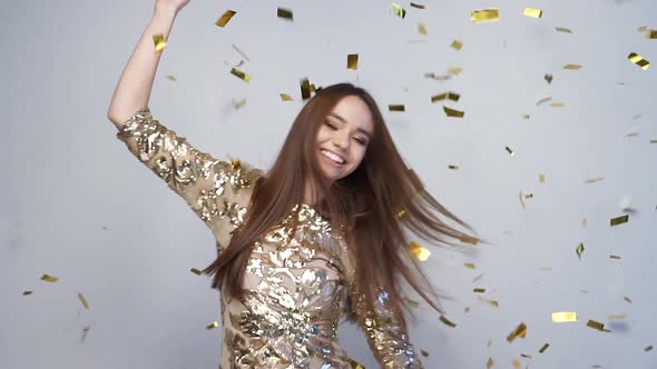 Celebration. Happy Woman Dancing With Confetti On White