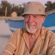 Portrait of senior fisherman in hat near his fishing boat - VideoHive Item for Sale