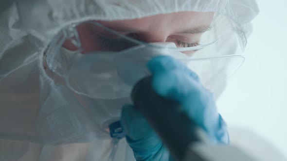 Virologist or Scientist is Looking Into Microscope alt