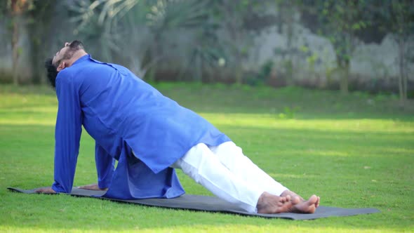 Indian man doing advanced yoga pose in an Indian traditional outfit Kurta Pajama