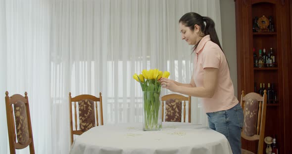 Brunette Woman Putting Yellow Tulip to Dinner Table