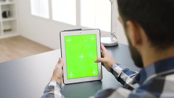Man Touching the Screen of a Digital Tablet PC with Green Mockup on It