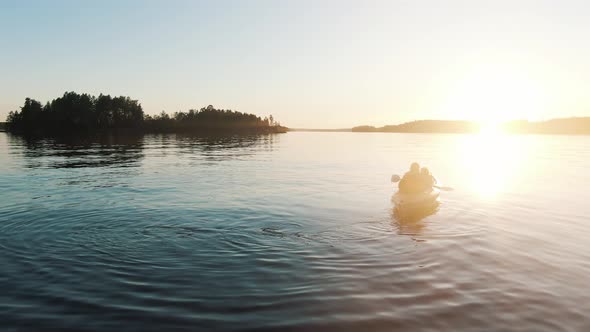 Aerial Young Woman Photographs Child in Boat Against Background of Stunning Sunset on Lake, Outdoor