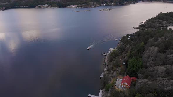 Drone view of boat leisurely cruising along coastline of Kragerofjorden, Norway