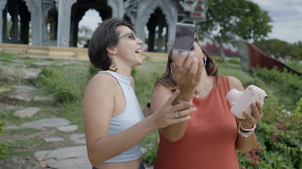 Asian Women Happily Checking The Outcome Of Their Photo From A Polaroid Camera In Ancient City