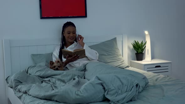 Pretty African American Woman Enjoys Reading an Interesting Book